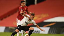 Gelandang Manchester United, Jesse Lingard, berebut bola dengan bek LASK, Reinhold Ranftl, pada laga leg kedua 16 besar Liga Europa 2019/2020 di Old Trafford, Kamis (6/8/2020) dini hari WIB. Manchester United menang agregat 7-1 atas LASK. (AFP/Oli Scarff)