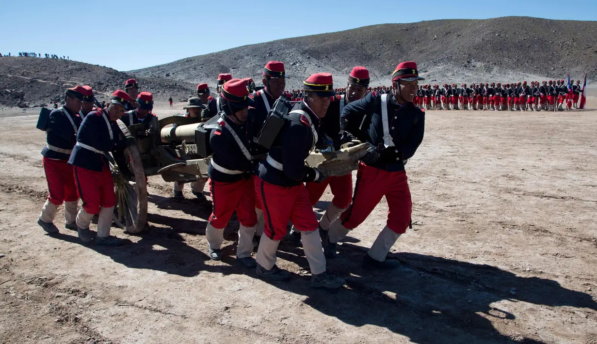 Prajurit Bolivia mengenakan kostum tentara Chili mendorong meriam ketika melakukan kembali pertempuran "Canchas Blancas," selama Perang Pasifik yang kalah dari Bolivia ke Chili pada tahun 1879 di Canchas Blancas, Bolivia (28/3). (AP Photo/Juan Karita)