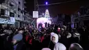 Sejumlah warga berkumpul saat perayaan malam Natal di kawasan Al-Hamidiyah kota tua Homs, Suriah, (24/12). Warga terpaksa merayakan malam Natal di tengah reruntuhan bangunan di daerah konflik tersebut. (REUTERS/Omar Sanadiki)