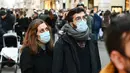 Orang-orang memakai masker di sepanjang jalan perbelanjaan mewah Via Condotti di pusat kota Roma, Italia, Minggu (5/12/2021). Kota Roma memberlakukan kewajiban penggunaan masker di ruang terbuka pusat kota dan area perbelanjaan sibuk lainnya hingga 31 Desember mendatang. (Vincenzo PINTO/AFP)