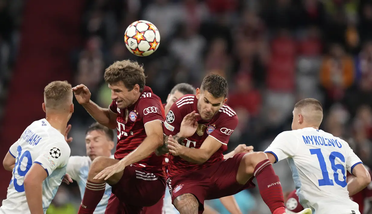 Penyerang Bayern Munchen, Thomas Mueller (kedua kiri) dan rekannya Lucas Hernandez melompat merebut bola saat bertanding melawan Dynamo Kiev pada pertandingan grup E Liga Champions di Allianz Arena, Munich, Jerman, Kamis (30/9/2021). Bayern menang atas Dynamo Kiev 5-0. (AP Photo/Matthias Schrader)