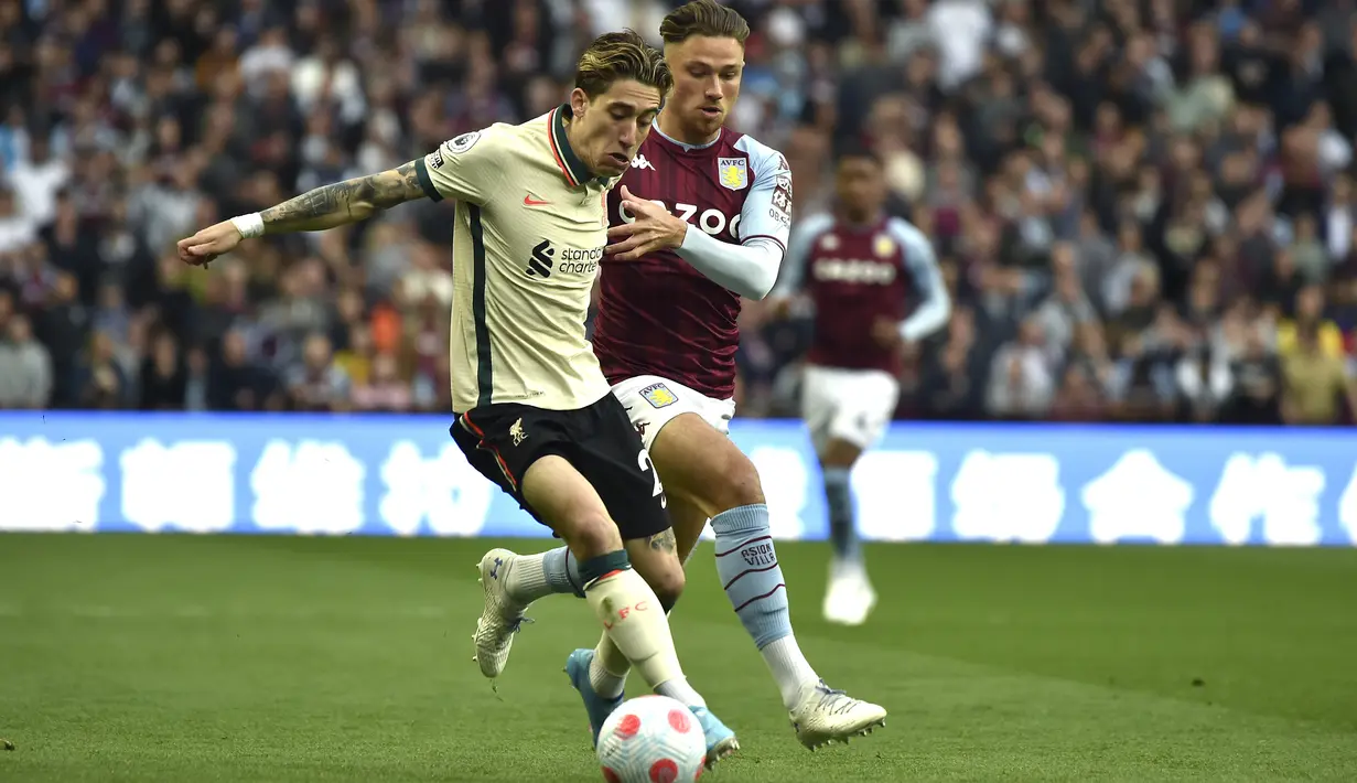 <p>Bek Liverpool Kostas Tsimikas (kiri) berebut bola dengan gelandang Aston Villa Matty Cash pada laga lanjutan Liga Inggris 2021/2022 di Villa Park, Rabu (5/11/2022) dini hari WIB. Liverpool menang tipis 2-1 atas tuan rumah Aston Villa. Gol kemenangan The Reds dicetak Sadio Mane. (AP Photo/Rui Vieira)</p>