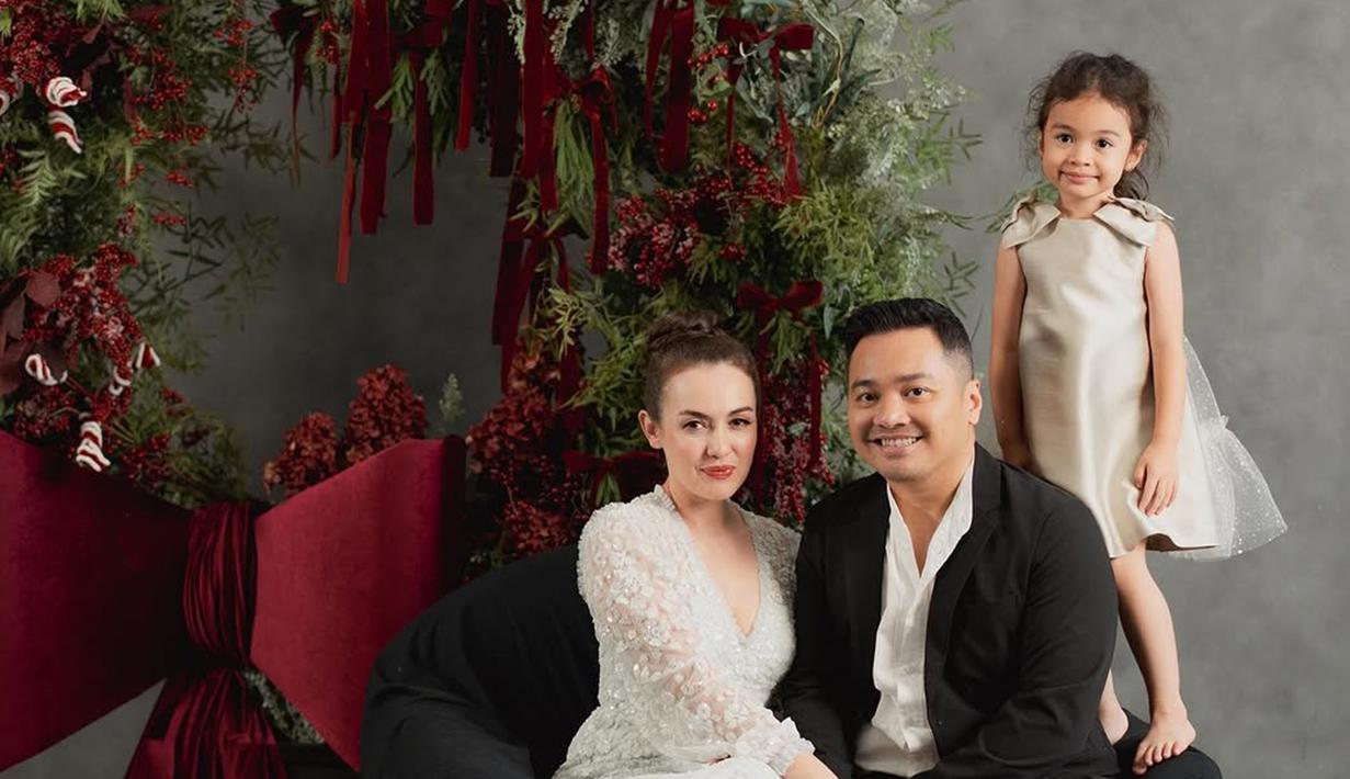 Rianti Cartwright tampil elegen dengan dress putih simpel dan rambut disanggul. Sementara sang suami gagah dengan setelah jas. Dalam momen ini buah hatinya tak kalah mencuri perhatian karena mengenakan dress sleveless selutut. Usianya telah menginjak 4 tahun, senyuman manis yang dipancarkan membuat tak sedikit netizen gemas dengan anak semata wayang Rianti ini. (Liputan6.com/IG/@riantic)