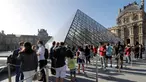 Pengunjung mengentre di piramida Louvre yang dirancang arsitek China Ieoh Ming Pei, pintu masuk ke Museum Louvre pada hari pertama pembukaan di Paris (6/7/2020). Setelah berbulan-bulan ditutup akibat lockdown Covid-19, Museum Louvre  kembali dibuka pada 6 Juli 2020. (AFP/Francois Guillot)