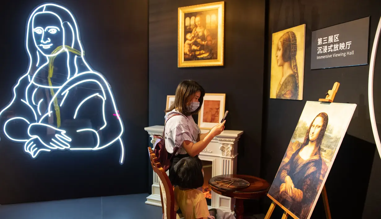 Seorang pengunjung mengabadikan gambar dalam sebuah pameran seni bertajuk Tribute to da Vinci yang digelar di gedung Changsha IFS, Changsha, Provinsi Hunan, China, Senin (4/5/2020). (Xinhua/Chen Sihan)