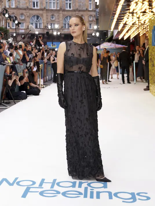 <p>Lawrence melengkapi penampilannya dengan heels runcing berwarna hitam. (Photo by Vianney Le Caer/Invision/AP)</p>