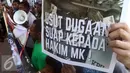 Warga Papua membawa beragam poster saat aksi di depan KPK, Jakarta, Senin (2/5). Mereka meminta KPK mengusut dugaan suap hakim MK di sengketa pilkada Teluk Bintuni (Liputan6.com/Helmi Afandi)