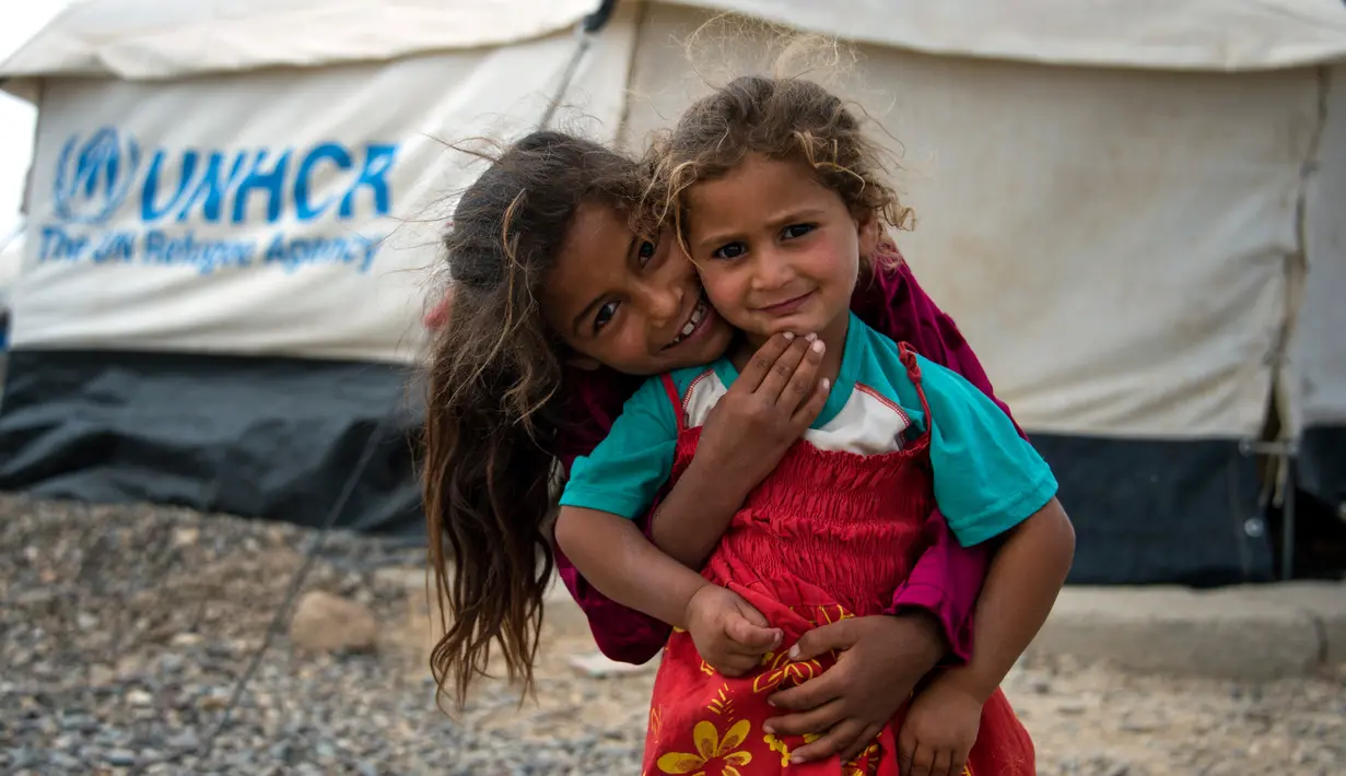 Anak-anak Irak berpose di sebuah kamp di Hammam al-Alil, Irak, Rabu (3/5). Pengungsi di kamp ini adalah warga Irak yang menyelamatkan diri dari ISIS di Mosul Barat. (AFP PHOTO / FADEL SENNA)