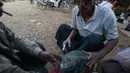 Seorang penambang melihat batu giok dengan jarum suntik berisikan heroin menempel ditubuhnya di Tambang batu giok di Hpakant, Myanmar, 29 November 2015. Kecanduan narkotika sudah merabak pada penambang batu giok. (REUTERS/Soe Zeya Tun)