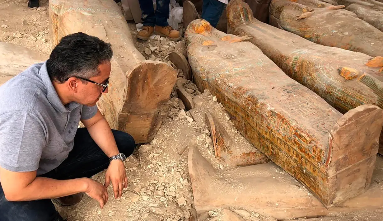 Menteri Purbakala Mesir Khaled el-Anany melihat penemuan 20 peti mati kuno di kota Luxor, 15 Oktober 2019. Peti mati ini terkubur dalam keadaan ditumpuk menjadi dua tingkatan, di mana ukiran asli wajah tangan pada peti masih terlihat jelas. (Egyptian Ministry of Antiquities via AP)