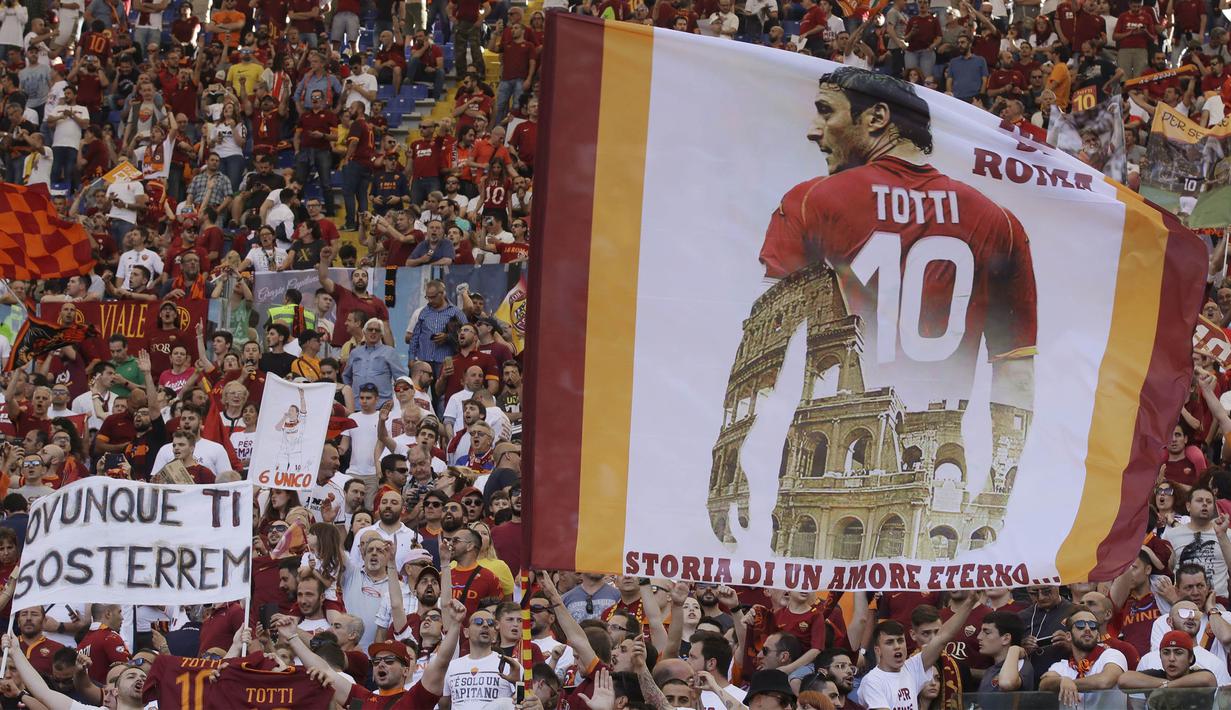 Supporter membawa bendera raksasa bergambar Francesco Totti saat laga terakhir sang legenda di Stadion Olimpico, Roma, Minggu (28/5/2017). Selama 25 tahun Totti berkarier di AS Roma. (AP/Alessandra Tarantino)