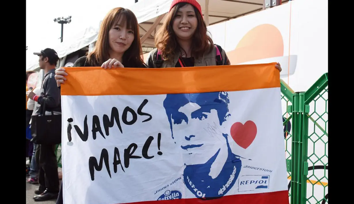 Penggemar olahraga MotoGP membentangkan bendera bergambar Marc Marquez, juara dunia MotoGP 2013 dan 2014, di Sirkuit Motegi, Jepang, (12/10/2014). (AFP PHOTO/Toshifumi Kitamura)