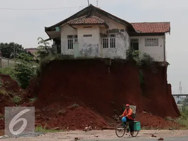 Warga melintas di samping Musala yang masih berdiri di lokasi pembangunan proyek Tol Cinere-Jagorawi di Depok, Jawa Barat, Selasa (1/11). Pembangunan Tol ini masih menyisakan 555 Bidang tanah yang belum dibebaskan. (Liputan6.com/Johan Tallo)