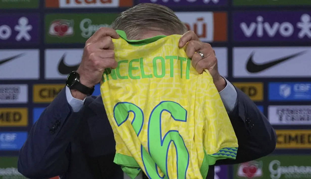 Carlo Ancelotti memegang jersey bertuliskan dirinya saat acara perkenalan pelatih baru Timnas Brasil di sebuah hotel di Barra da Tijuca, Rio De Janeiro, Brasil, Senin (26/05/2025) waktu setempat. (AP Photo/Silvia Izquierdo)