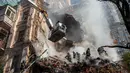 Petugas pemadam kebakaran bekerja setelah sebuah serangan pesawat tak berawak di gedung-gedung di Kyiv, Ukraina, Senin (17/10/2022).  Pesawat tak berawak menghantam sejumlah gedung ibu kota Ukraina pada Senin pagi ledakan tesebut menggema di seluruh Kyiv dan menimbulkan kepanikan sehingga orang-orang berlarian ke lokasi yang aman. (AP Photo/Roman Hrytsyna)