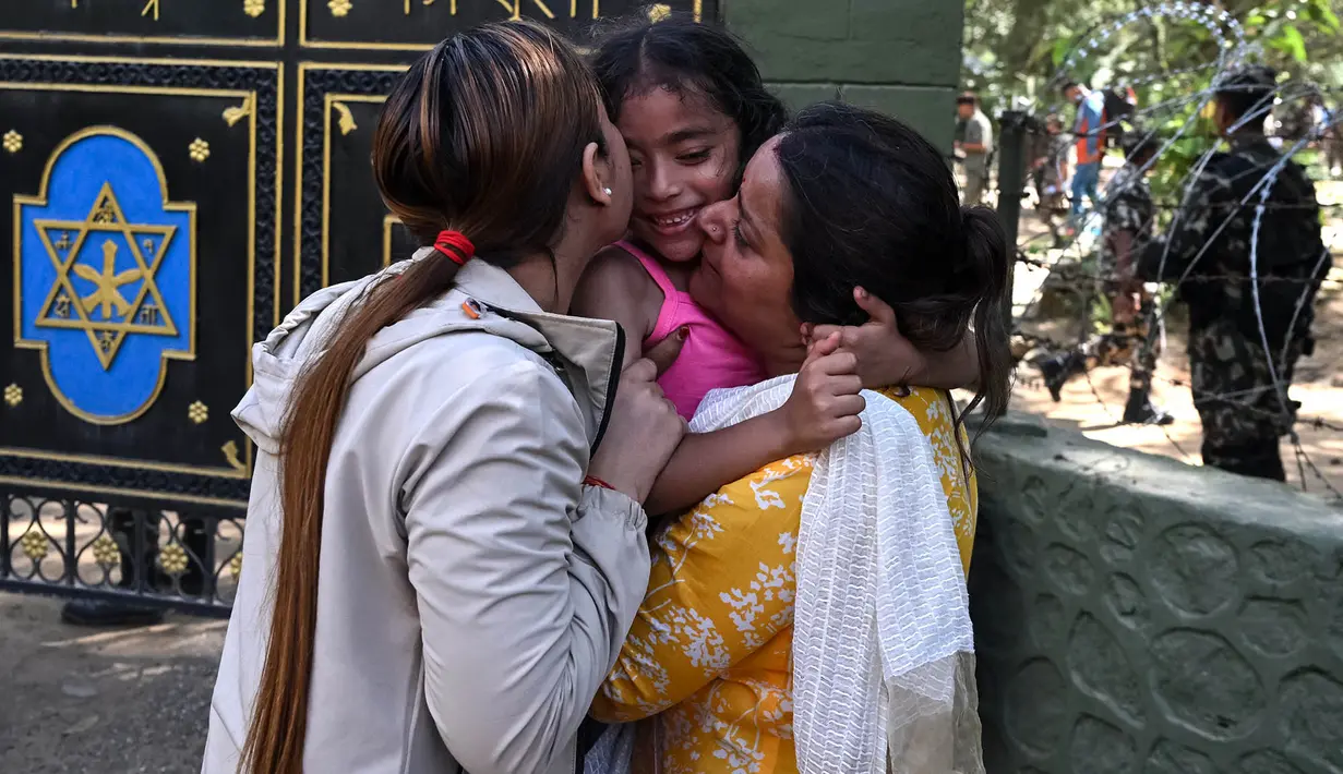 Seorang gadis dipeluk oleh anggota keluarganya setelah diselamatkan dari lokasi banjir bandang di kamp Trishuli, Distrik Nuwakot, Nepal, Jumat, 28 Agustus 2026. (AFP/ Arun Sankar)