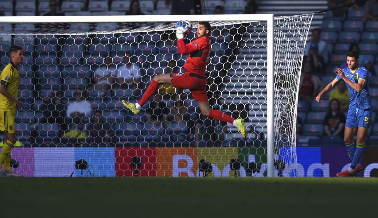Di sisi lain, kiper Ukraina, Heorhiy Bushchan juga beberapa kali melakukan penyelamatan untuk mengamankan gawang mereka. Pertandingan di awal babak pertama berjalan imbang dan saling serang. (Foto: AP/Pool/Stu Forster)