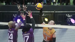 Pemain Jakarta Popsivo Polwan, Irina Voronkova (kanan) melepaskan spike yang berusaha diblok dua pemain Jakarta BIN, Wilda Siti Nurfadhilah (tengah) dan Kenia Carcaces pada laga putaran pertama final four PLN Mobile Proliga 2024 di GOR Bung Tomo, Surabaya, Minggu (7/7/2024). Jakarta Popsivo Polwan kalah 0-3 (13-25, 35-37, 24-26). (Dok. PBVSI)