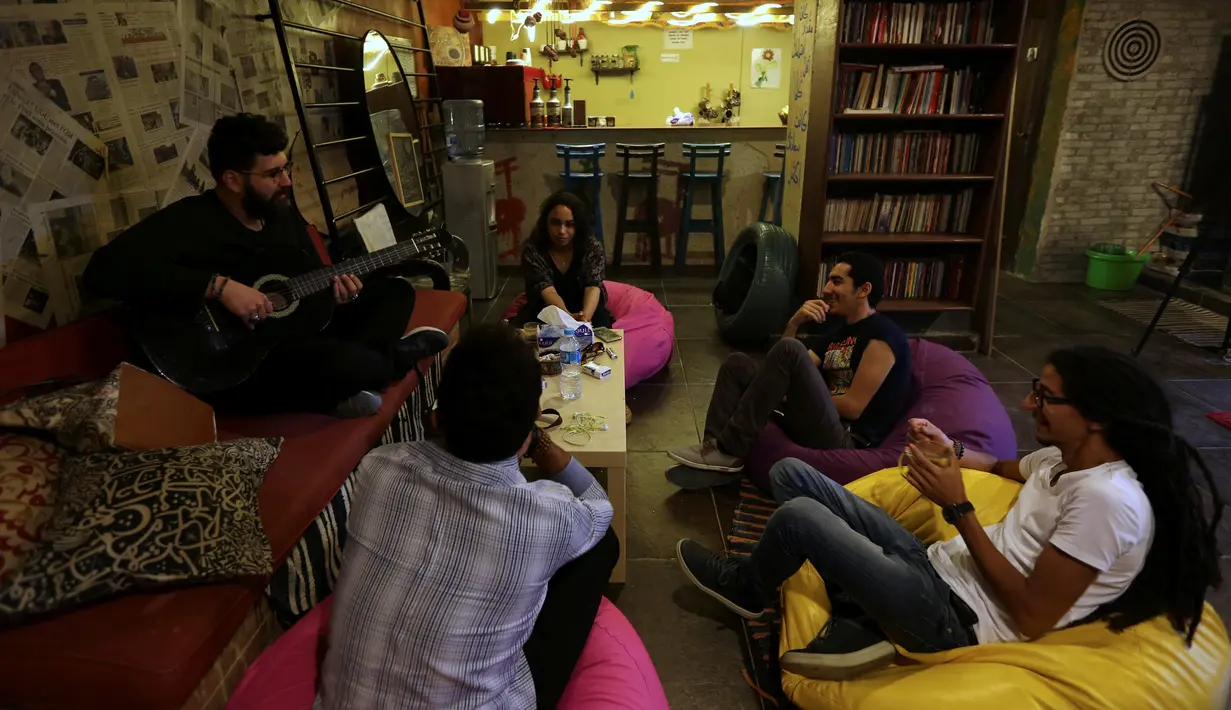 Pengunjung berdiskusi sambil bermain musik saat berada di "scream room" dalam perpustakaan di Kairo, Mesir, (23/10). (REUTERS/Mohamed Abd El Ghany)