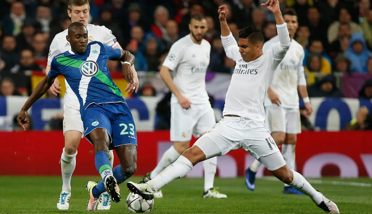 Gelandang Real Madrid, Casemiro (kanan) berebut bola dengan gelandang Wolfsburg, Josuha Guilavogui di leg kedua liga Champions di Santiago Bernabeu, Spanyol (13/4). Madrid menang atas Wolfsburg dengan skor 3-0. (Reuters/Sergio Perez)