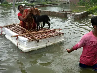Seorang anak mengangkut ibu beserta hewan-hewan ternaknya menggunakan perahu darurat di sebuah desa di Distrik Muzaffarpur, Negara Bagian Bihar, India timur, 26 Juli 2020. Sedikitnya 10 orang tewas dan hampir 1,5 juta orang terkena dampak akibat banjir di 11 distrik di Bihar. (Xinhua/Partha Sarkar)