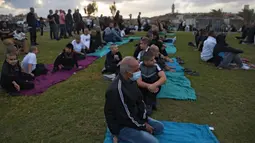 Umat muslim berkumpul untuk melaksanakan salat Idul Fitri yang menandai berakahirnya bulan suci Ramadan di sebuah taman di Jaffa, Israel, Minggu (24/5/2020). Jaffa merupakan kota campuran Yahudi-Arab. (AP Photo/Oded Balilty)
