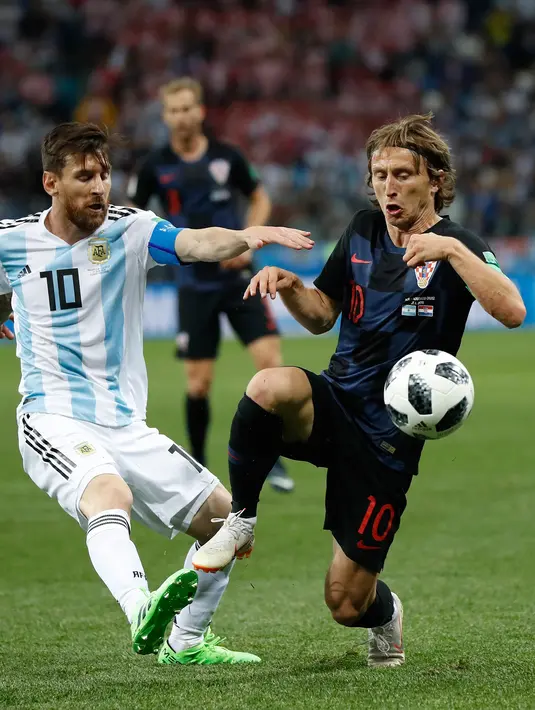 Megabintang Argentina, Lionel Messi berebut bola dengan pemain Kroasia, Luka Modric pada pertandingan Grup D Piala Dunia 2018 di Nizhy Novgorod Stadium, Rusia, Jumat (22/6). Menghadapi Kroasia, Argentina takluk dengan skor 0-3.. (AP/Petr David Josek)