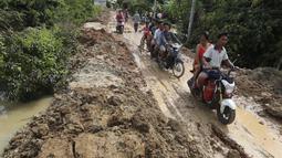 Penduduk desa melakukan perjalanan di dekat bendungan Stung Prek Tnaot setelah banjir menyusul hujan di pinggiran Phnom Penh, Kamboja (14 /10/2020). Pejabat bencana Kamboja mengatakan bahwa lebih dari 10.000 orang telah dievakuasi ke tempat aman setelah badai tropis melanda. (AP Photo/Heng Sinith)