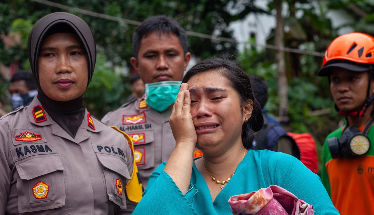Seorang wanita menangis dekat Tim SAR saat menemukan keluarganya yang meninggal dalam bencara tanah longsor di Gowa, Sulawesi Selatan, Jumat (25/1). Hingga 25 Januari 2018, tercatat 33 orang meninggal dunia. (YUSUF WAHIL/AFP)