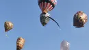 Warga melihat balon-balon udara yang terbang saat Java Balon Festival di Stadion Hoegeng, Pekalongan, Jawa Tengah, Rabu (12/06/2019). Sebanyak 105 bersaing untuk memperebutkan hadiah total Rp 70 juta. (Liputan6.com/Gholib)