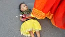 Seorang wanita menginjak anaknya untuk mencari berkah dari Dewa Matahari selama mengikuti festival keagamaan Chhat Puja di Kolkata, India (6/11). (Reuters/Rupak De Chowdhuri)