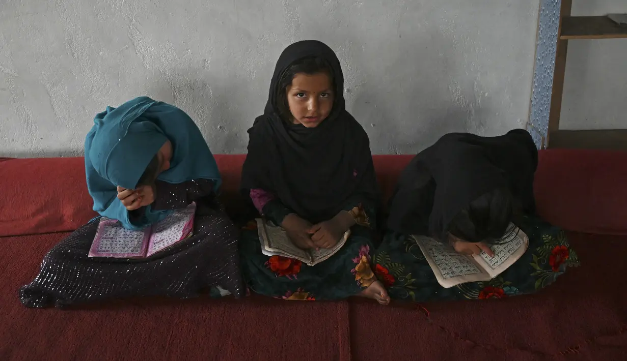 Anak-anak membaca Alquran selama bulan suci Ramadhan di sebuah masjid di pinggiran Kabul, Afghanistan, Selasa (27/4/2021).  Bulan Ramadhan menjadi momen untuk memperbanyak amalan, termasuk ketekunan menjalani tadarus Alquran. (WAKIL KOHSAR / AFP)