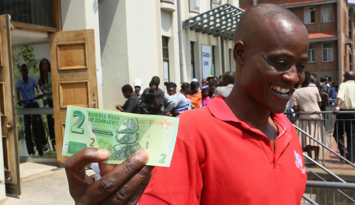 Seorang pria menunjukkan salah satu uang kertas baru yang dikeluarkan Reserve Bank of Zimbabwe di Harare, 12 November 2019. Pemerintah Zimbabwe memperkenalkan kembali mata uang negaranya setelah hampir sedekade terakhir menggunakan mata uang negara lain untuk bertransaksi. (AP/Tsvangirayi Mukwazhi)