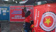 Buruh perempuan berdiri di depan tenda protes di depan gerbang PT Sokolancar/Bapintri, Kota Cimahi, Jawa Barat, Kamis, 28 Maret 2024. (Dikdik Ripaldi/Liputan6.com)