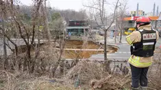 Seorang penyelidik mengambil foto lubang runtuhan di luar sebuah toko tanaman di sebuah jalan di Seoul, Korea Selatan pada tanggal 25 Maret 2025. (Anthony WALLACE/AFP)