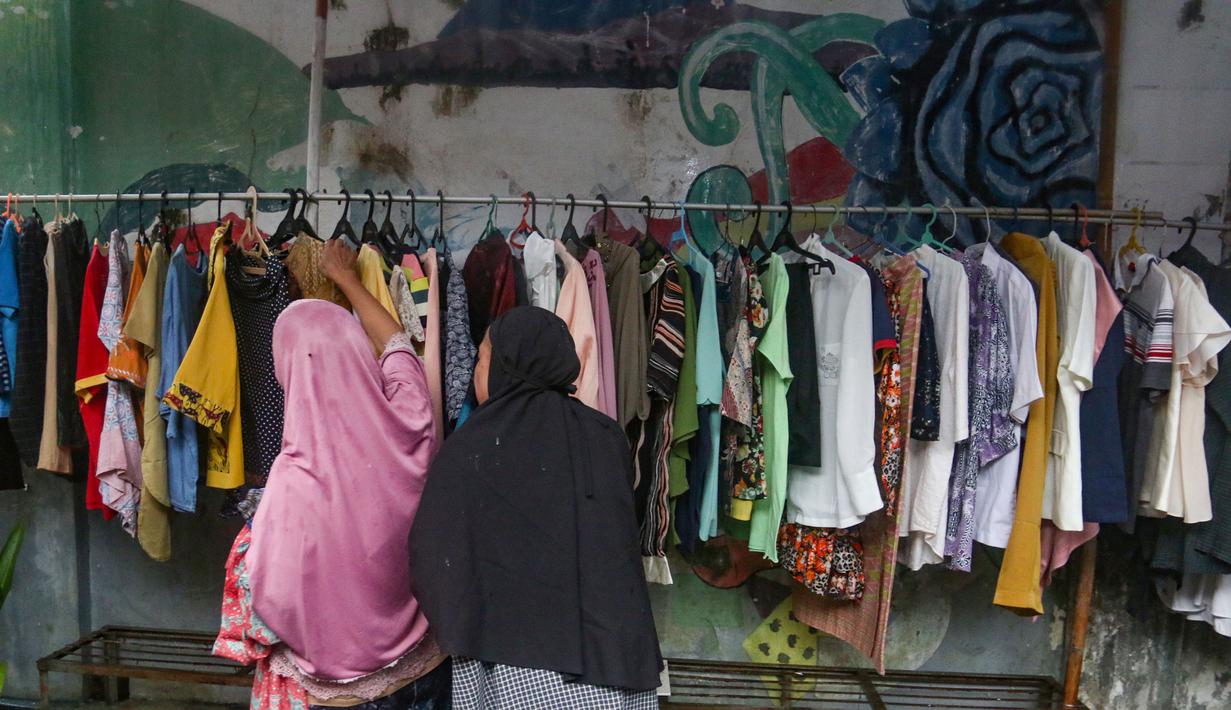 Bantuan yang dibagikan berupa pakaian layak pakai dan bahan makanan yang berasal dari sumbangan warga sekitar. Tampak dalam foto, warga memilih pakaian layak pakai yang dibagikan secara cuma-cuma di permukiman RT 02/RW 04 kawasan Jati Padang, Jakarta, Jumat (6/3/2026). (merdeka.com/Arie Basuki)