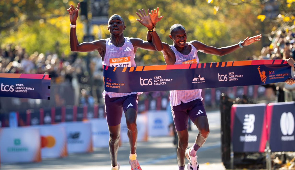 Pelari Kenya, Benson Kipruto (kiri) dan kompatriotnya, Alexander Mutiso melintasi garis finis pada ajang New York Marathon 2025 pada Minggu (02/11/2025) waktu setempat. Ini menjadi finis dengan jarak terdekat dalam ajang maraton dengan selisih 0,03 detik. (AP Photo/Angelina Katsanis)