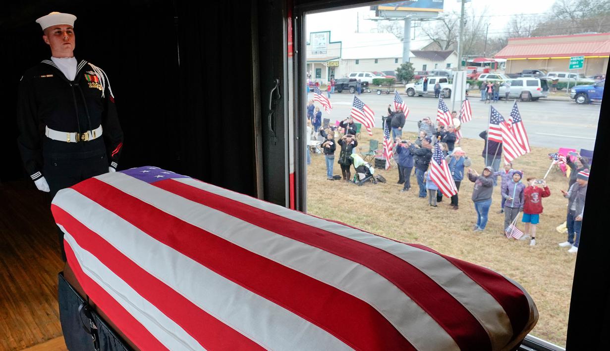 Anggota militer menjaga peti jenazah Presiden ke-41 AS George HW Bush dalam kereta saat melintasi Magnolia, Texas, Kamis (6/12). Jenazah Bush akan dimakamkan di samping mendiang istrinya, Barbara dan putrinya, Robin. (AP Photo/David J. Phillip, Pool)