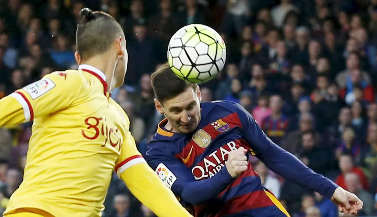 Lionel Messi (kanan), melakukan duel udara dengan pemain Sporting Gijon, Igor Lichnovsky, pada lanjutan La Liga Spanyol di Stadion Camp Nou, Barcelona, Sabtu (23/4/2016). (Reuters/Albert Gea)
