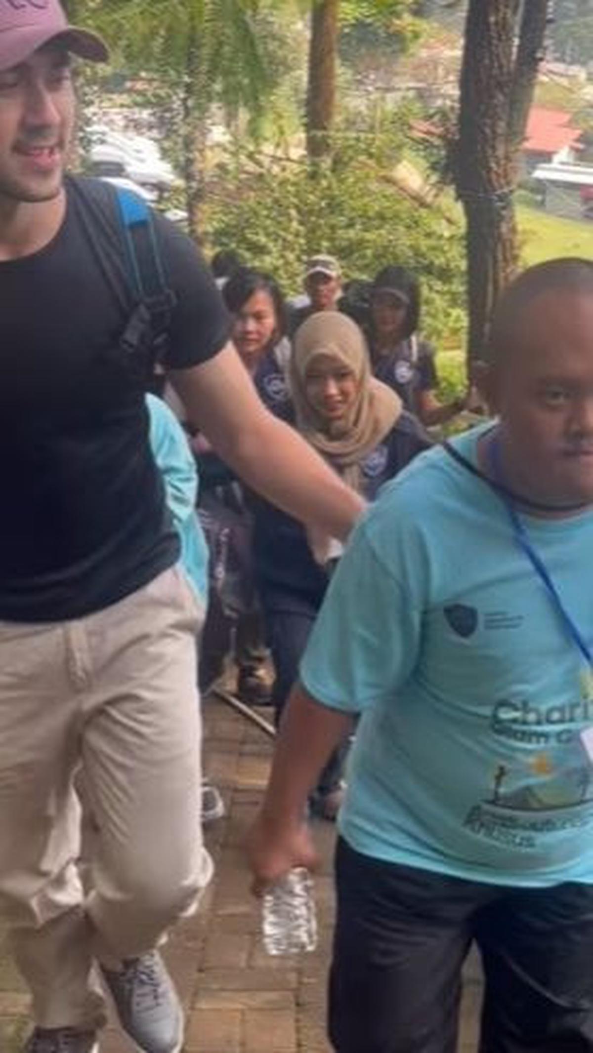 Dengan penuh antusiasme, Shanon menemani salah satu anak untuk menjelajahi alam dengan melakukan trekking, menciptakan momen petualangan yang menggembirakan.<br>