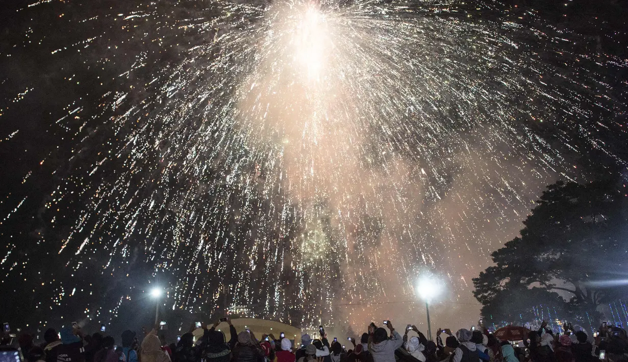 Para pengunjung mengabadikan gambar saat Balon udara panas meletus, mengeluakan percikan kembang api saat Festival Tazaungdaing di Taunggyi, Myanmar (12/11). (AFP/Ye Aung Kamis)