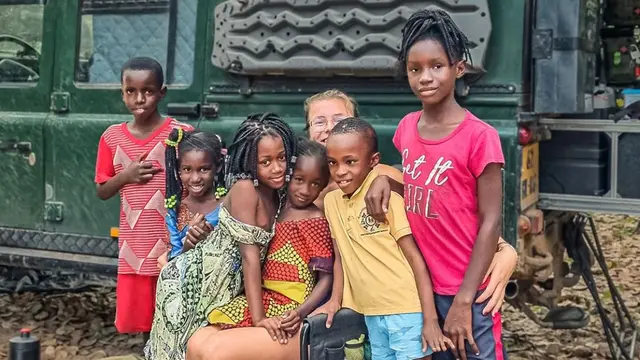 Seorang turis sedang bersama anak-anak di Guinea, Afrika