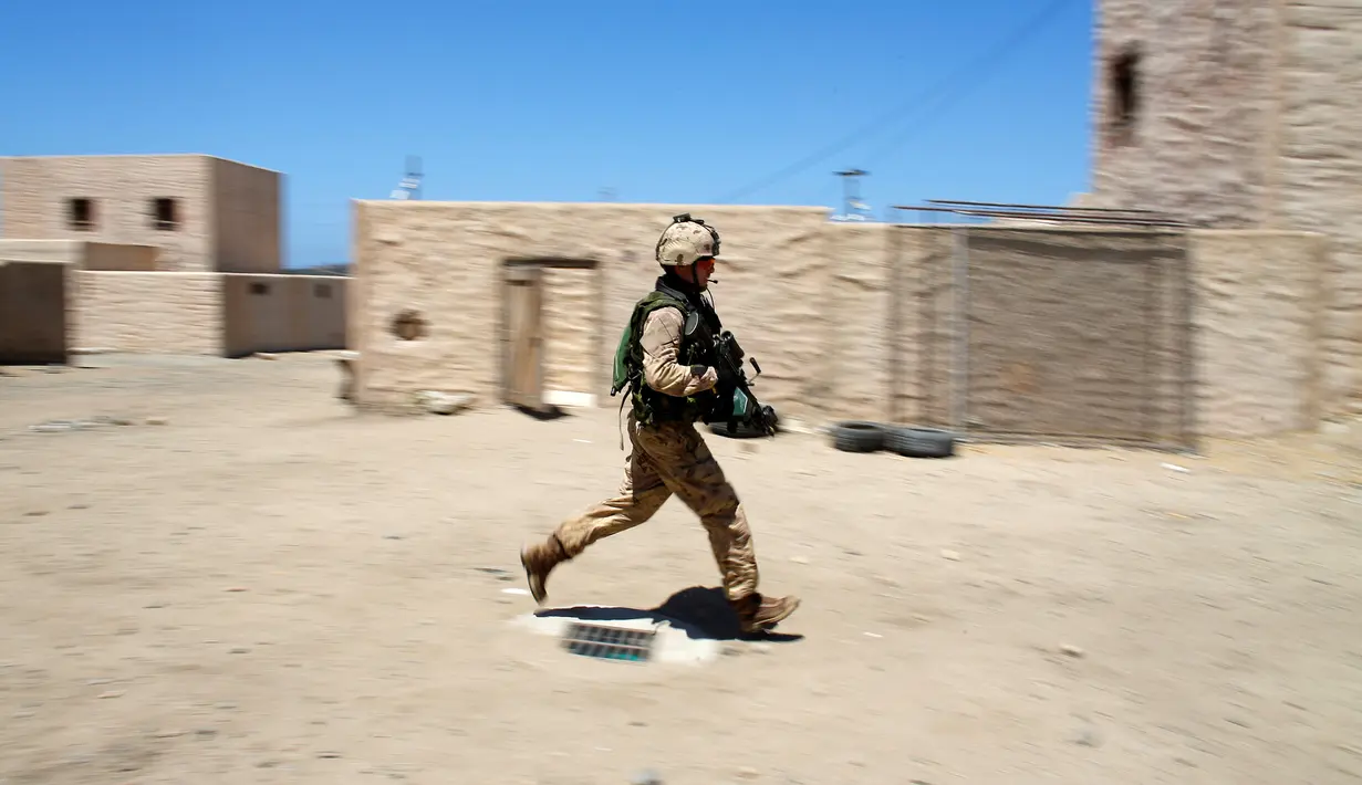 Seorang tentara Kanada dari Royal 22 Resimen berlari saat melakukan patroli selama operasi ekstraksi non-agresif di sebuah desa dalam simulasi latihan Rim Pasifik (RIMPAC) 2016 di Camp Pendleton, California, Amerika Serikat, (11/7). (REUTERS/Mike Blake)