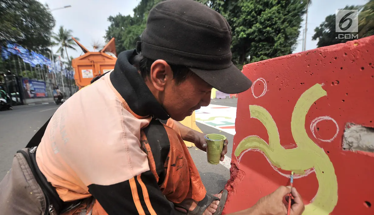 Pekerja dari PPSU Kelurahan Pegangsaan saat membuat lambang cabang olahraga di pembatas Jalan Penataran atau Simpang Tugu Proklamasi, Jakarta, Rabu (25/7). (Merdeka.com/Iqbal S. Nugroho)