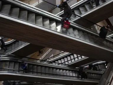 Orang-orang menaiki eskalator yang kosong saat pembukaan kembali pusat perbelanjaan Costanera di Santiago, Chile, 18 Agustus 2020. Pihak berwenang Chile berharap melanjutkan peta jalan untuk membuka kembali Ibu Kota secara penuh, sambil menerapkan jarak sosial yang ketat. (AP Photo/Esteban Felix)