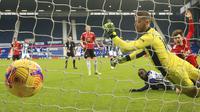 Penyerang West Brom, Mbaye Diagne, menyarangkan gol ke gawang Manchester United yang dijaga David de Gea pada lanjutan Liga Inggris 2020/2021, Minggu (14/2/2021) malam WIB. (Nick Potts/Pool Photo via AP)