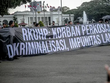 Anggota Jaringan Solidaritas Korban untuk Keadilan (JSKK) melakukan Aksi Kamisan ke-755 di seberang Istana Merdeka, Jakarta, Kamis (1/12/2022). Dalam aksinya mereka meminta Presiden Joko Widodo memperhatikan pasal bermasalah pada draf Rancangan Kitab Undang-Undang Hukum Pidana (RKUHP) yang telah mendapat persetujuan tingkat pertama oleh Komisi III DPR dan pemerintah. (Liputan6.com/Faizal Fanani)