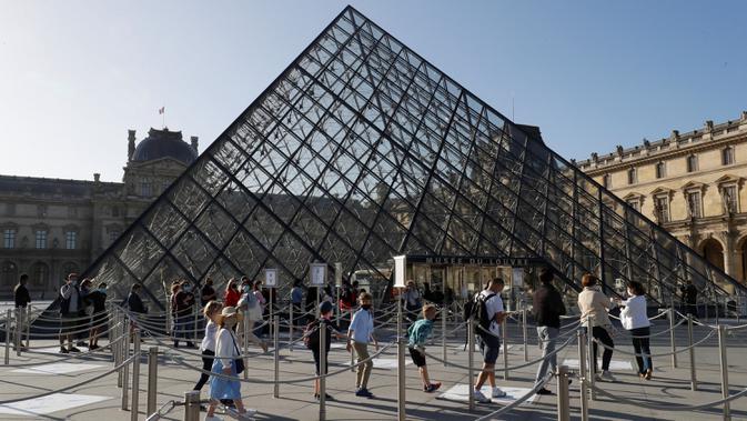 <p>Pengunjung mengentre di piramida Louvre yang dirancang arsitek China Ieoh Ming Pei, pintu masuk ke Museum Louvre pada hari pertama pembukaan di Paris (6/7/2020). Setelah berbulan-bulan ditutup akibat lockdown Covid-19, Museum Louvre kembali dibuka pada 6 Juli 2020. (AFP/Francois Guillot)</p>
