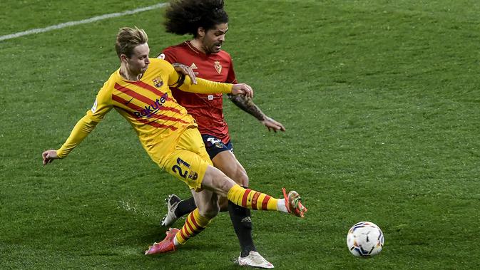 Gelandang Barcelona, Frenkie de Jong mencoba menembak bola dari kawalan pemain Osasuna, Aridane pada pertandingan lanjutan La Liga Spanyol di stadion El Sadar di Pamplona, Minggu (7/3/2021). Barcelona sukses menjaga jarak dua poin dengan pemuncak klsemen Atletico Madrid. (AP Photo/Alvaro Barrientos)