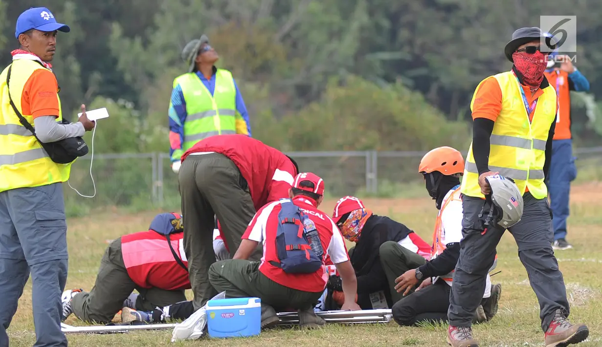 Petugas mengevakuasi atlet paralayang putri asal Malaysia Sharifah Nadiah Wafa saat bertanding pada nomor ketepatan mendarat Asian Games 2018, Bogor (21/8). Sharifah diduga mengalami cedera bagian pinggul kaki kanan ke bawah. (Merdeka.com/Arie Basuki)